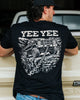 Person wearing a black t-shirt with 'YEE YEE' and graphic design, standing next to a vehicle.